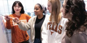 Four students look at a whiteboard